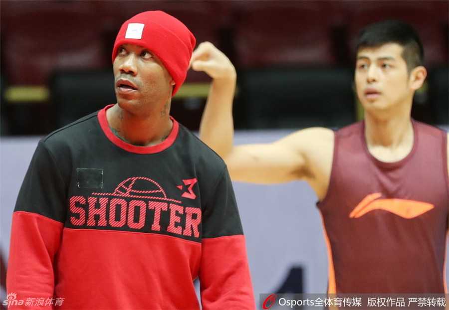 北京男篮精神领袖马布里头顶红色训练帽，如同冬日里的焰火，在训练场上格外醒目，他专注地控球，仿佛一切尽在掌握。