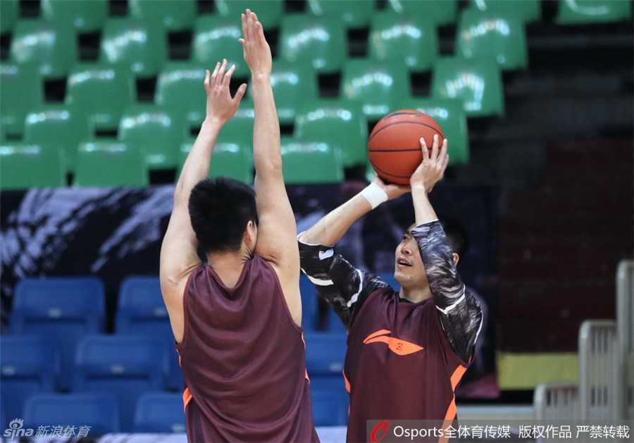 北京队另一名外援莫里斯在训练师的协助下进行拉伸，肌肉线条分明，眼神坚定，他为这次CBA赛季的备战倾注了全部心力。