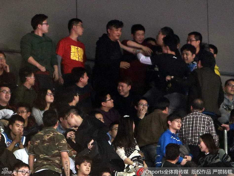 京疆决战夜的五棵松:球迷骚乱与卫冕冠军的悲情谢幕 人潮拥挤的看台通道内,几名戴着蓝色帽子的安保人员奋力组成人墙,用身体隔开情绪亢奋的球迷,球迷们则踮起脚尖、伸长脖子,试图从人墙缝隙中挤向前方。