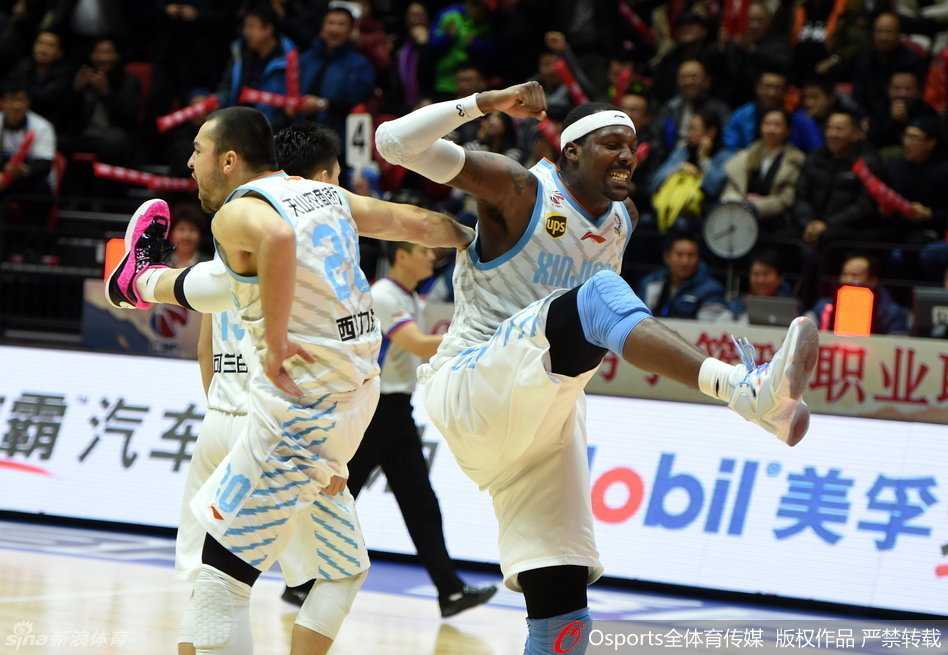 周琦痛苦地蜷缩在篮架下的地板上，眉头紧锁，汗水浸湿了球衣。队友们围成一圈，俞长栋单膝跪地，小心翼翼地按压着周琦拉伤的大腿，眼神中满是关切与担忧。