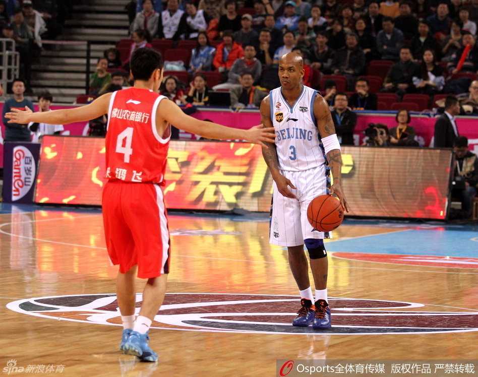 京粤大战经典再现 首钢众将演绎团队篮球真谛 马布里眼神坚毅,面对防守从容地运球穿越人群,举手投足间尽显领袖风范,正在组织一次关键的进攻配合。
