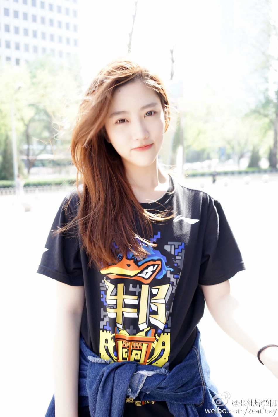 身披北京冠军纪念衫的她，在霓虹闪烁的街角留下俏皮回眸，纤细的身影透着活力的光芒。