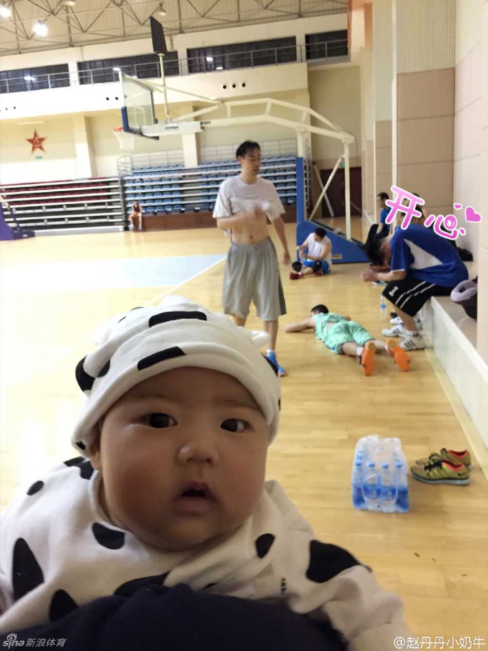 孟达在空荡的球馆内运球热身，远处的座椅上，他的妻子抱着女儿静静注视，整个画面充满了温情与陪伴。