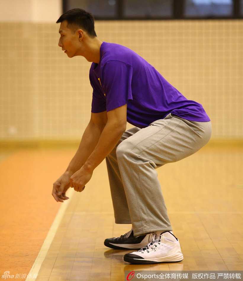 冬日暖阳下的八冠王:重温广东男篮二零一六新春集训点滴 易建联在力量区进行负重深蹲训练,汗水已浸湿背心,大腿肌肉紧绷如雕塑,眼神坚毅地直视前方。