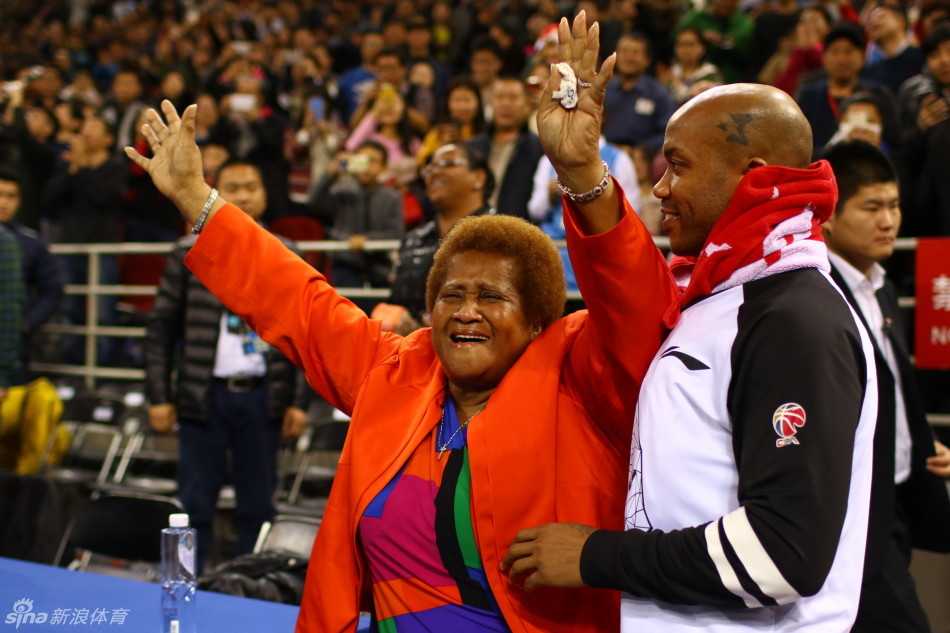 北京寒冬里的温情瞬间:马布里与母亲的深情相拥 马布里搀扶着腿脚不便的母亲,小心翼翼地在更衣室通道中前行,他的眼神始终关注着母亲的脚步,画面温馨而感人。