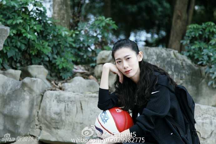 午后的阳光下，她身穿休闲装坐在球场边，回眸一笑，青春的气息与运动的背景完美融合，仿佛漫画中走出的学姐