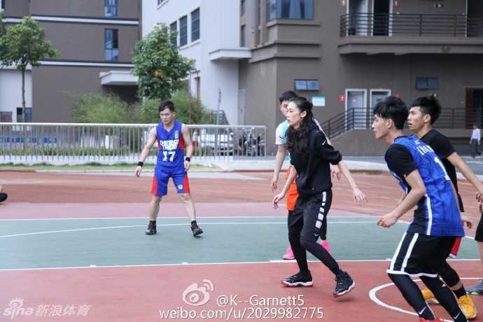 她穿着加内特的球衣在球场驻足，身后是斑驳的防护网，眼神中满是对偶像和篮球纯粹的热爱