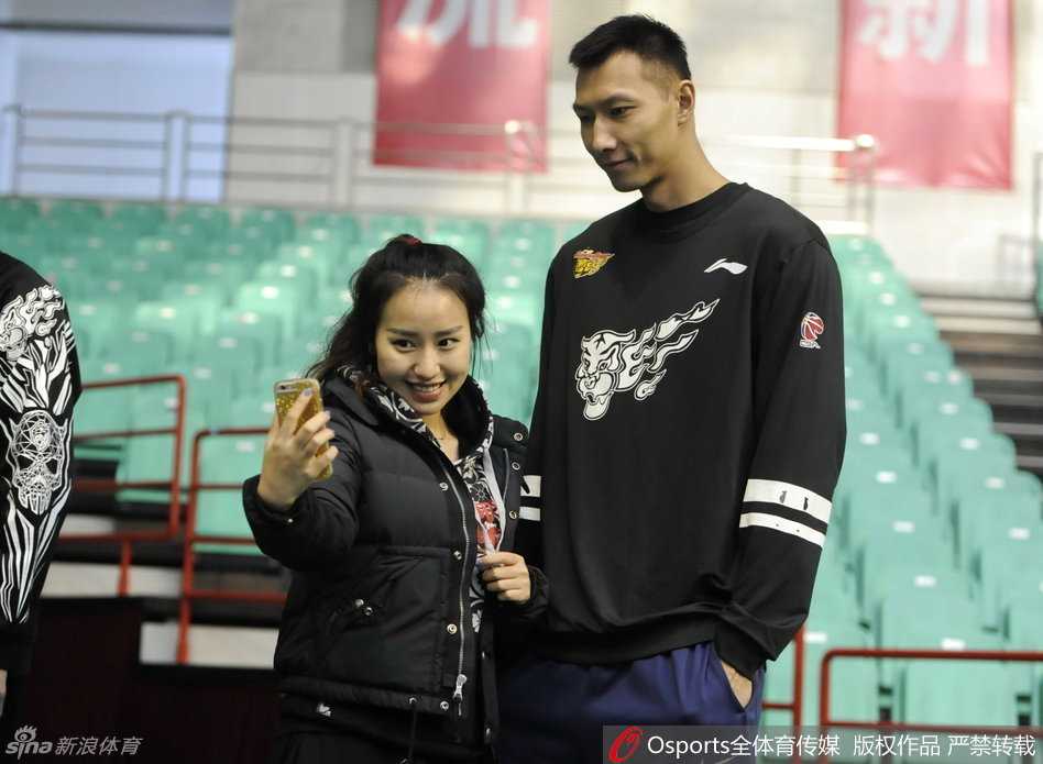 “大哥”易建联在训练间隙被热情的球迷拦住合影，他微微低头，标志性的腼腆笑容里带着一丝温暖，完全没有了球场上的凌厉杀气。