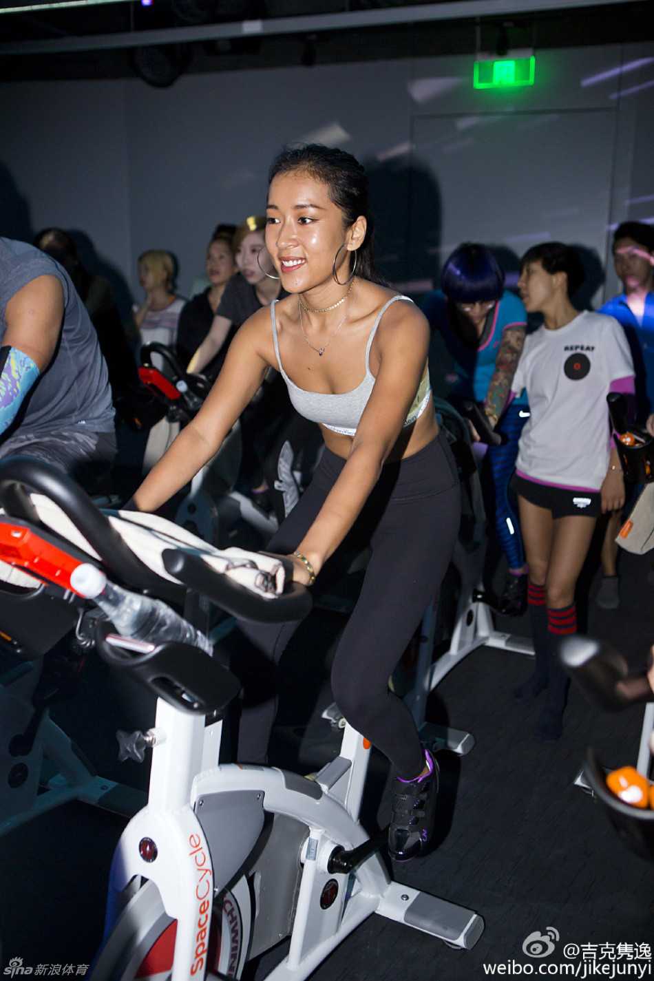 吉克隽逸的野性美学:雕刻性感曲线,从单车苦训到盛装助威中国男篮 吉克隽逸与中国男篮队员们合影,她被高大的球员们簇拥在中间,脸上带着灿烂又有些俏皮的笑容,一身红色队服格外醒目,画面充满动感与和谐