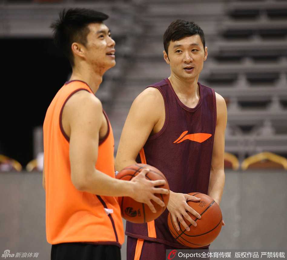 李根投出三分球后保持出手姿势，眼睛紧盯着篮球的飞行轨迹，表情认真