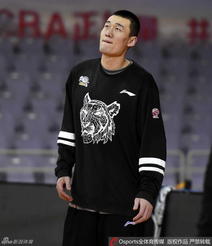 李根坐在场边休息时突然陷入沉思，眼神迷离地看着远方，仿佛在回忆往事或思考今晚的战术。