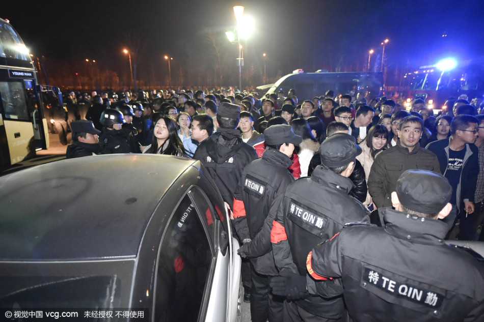 太原寒夜·人墙之后:回望京晋大战的激情与秩序 一名戴眼镜的安保人员神情紧绷,他张开双臂,努力拦截着向前涌动的球迷。身后是无数双挥舞的手,身前是亟待维护的赛场底线,他的背影在球迷组成的人潮映衬下,显得孤独却又坚不可摧。