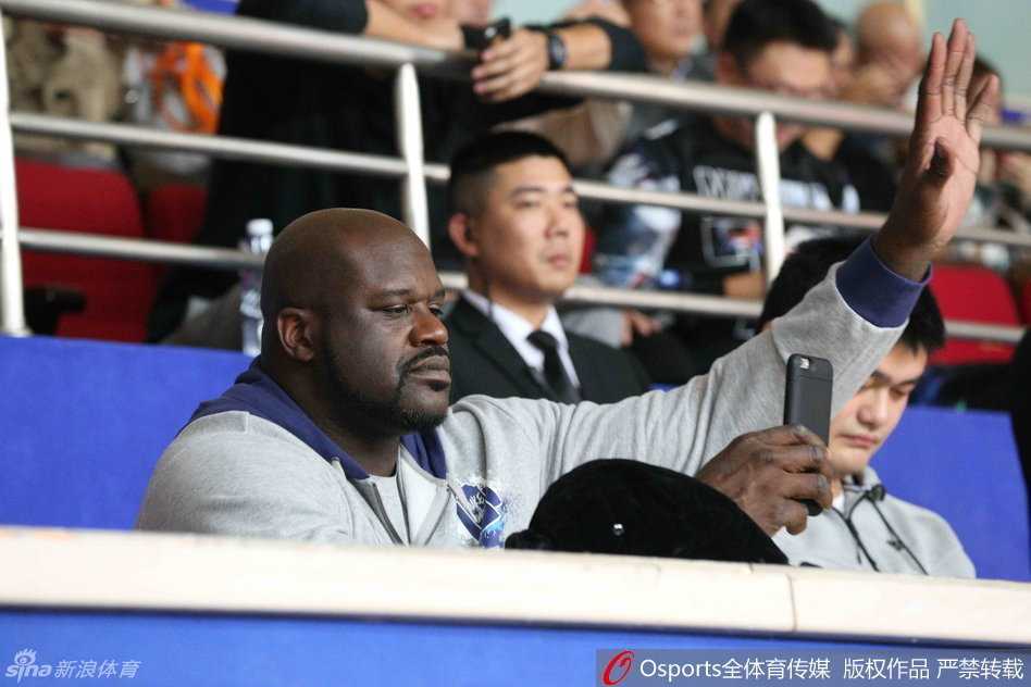 姚明邀鲨鱼奥尼尔助阵,大鲨鱼主场取胜背后的欢笑与温情 奥尼尔调皮地拿起手机对准姚明拍照,而姚明则面带微笑地看向镜头,两人之间的互动充满了老友重逢的趣味与温馨。