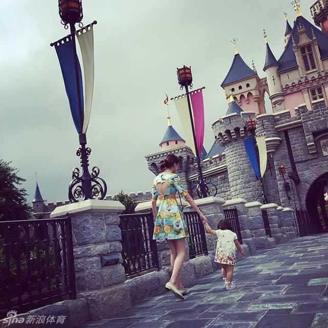 孙悦爱妻陈露携女畅游迪士尼,温馨母爱洋溢童话王国 小家伙似乎被某个精彩的表演完全吸引住了,目不转睛地看着前方,神情专注而认真。陈露在一旁默默守护着这份纯真的好奇与快乐,画面安静而美好。