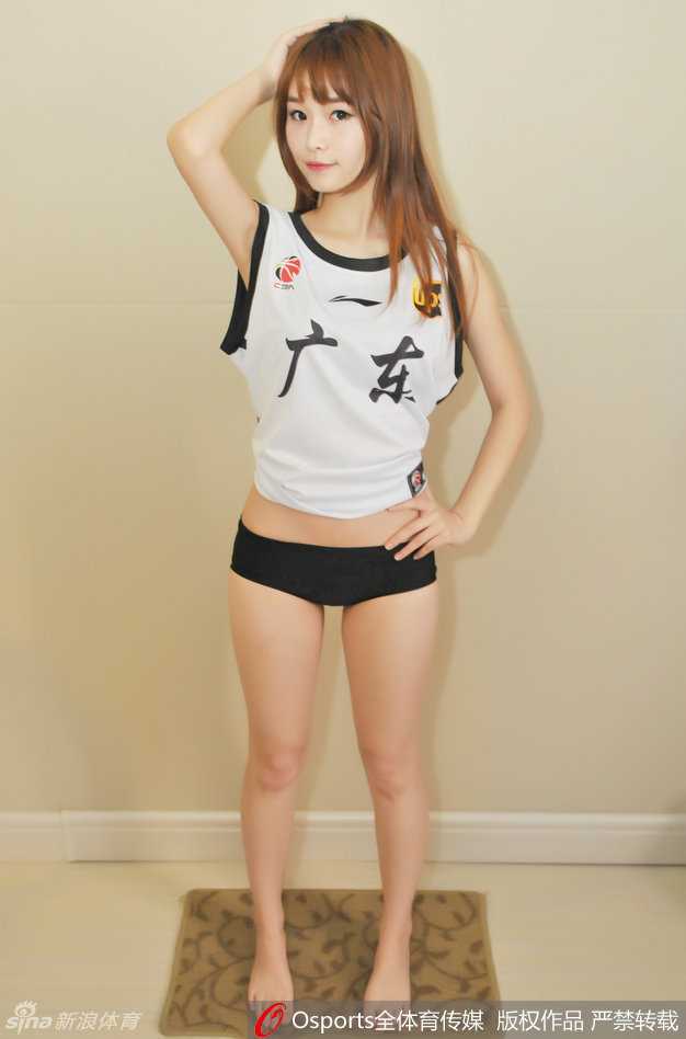 宝贝侧身站立，纤腰长腿在聚光灯下勾勒出完美曲线，手中的花球仿佛也被她的热情点燃，闪耀着动人的光泽。