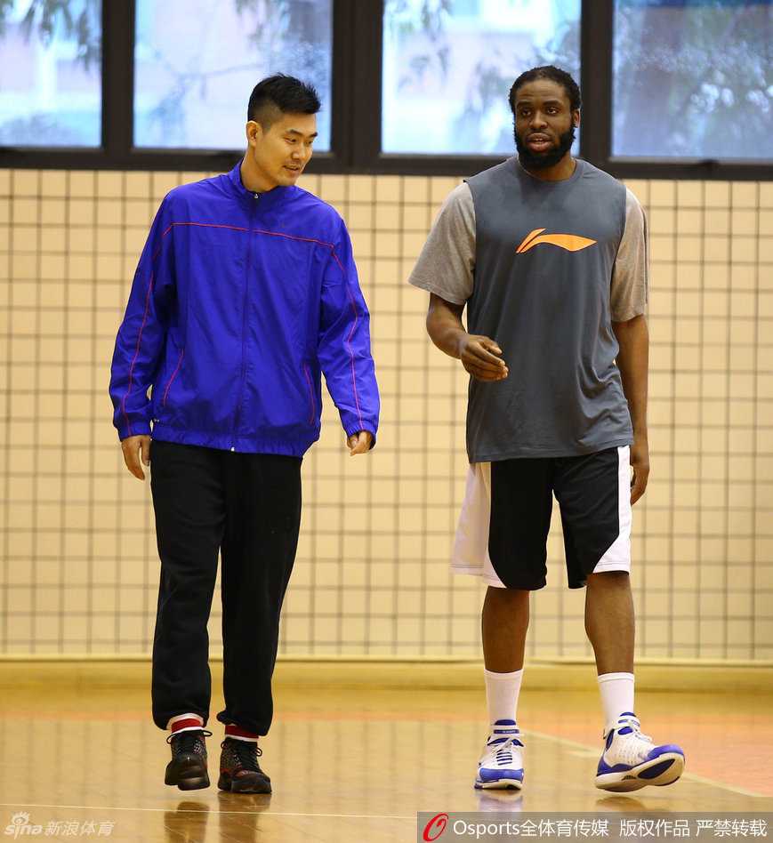广东男篮春节前最后一练 易建联秀腹肌迪奥古萌态可掬 迪奥古与王仕鹏进行战术沟通,王仕鹏面带自信笑容,比划着新的跑动路线