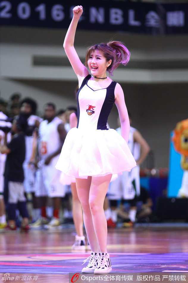 即使在休息间隙，这位短发妹子也依旧是镜头的焦点。她安静地站在场边，但那抹自信的微笑和清爽的短发造型，在一袭白裙的映衬下，显得格外俏皮可爱，成为了镜头追逐的宠儿。