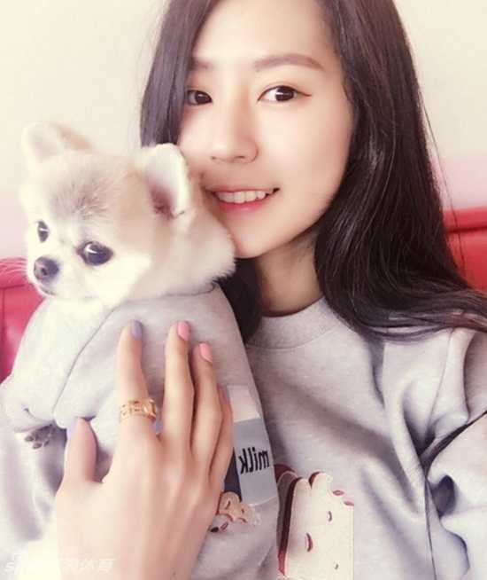 怀拥爱犬嘟嘴卖萌,完美侧颜回眸一笑:韩国最美啦啦队长朴姬兰的甜辣魅力 朴姬兰面对镜头嘟嘴卖萌,作出撒娇状,眼神灵动俏皮,完美侧颜展现出精致的脸部线条。