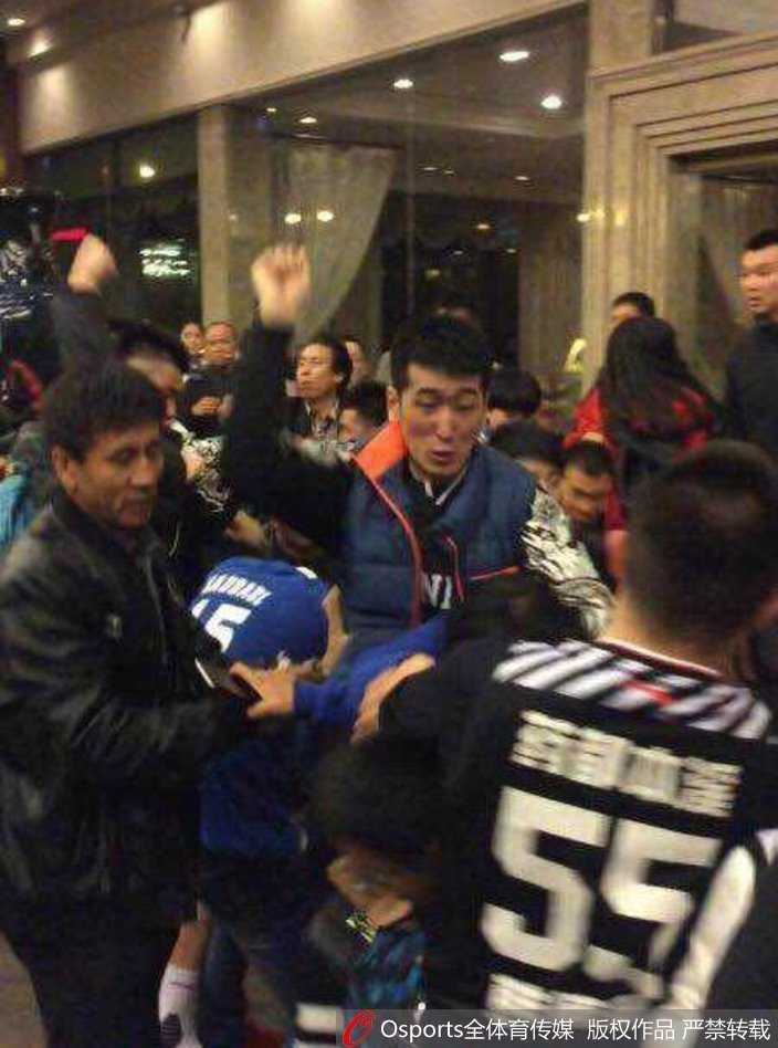 人高马大的韩德君在人群中格外显眼，他神情激动地挥起手臂，身旁的队友和工作人员拼命拉住他，试图阻止他进一步卷入冲突之中。