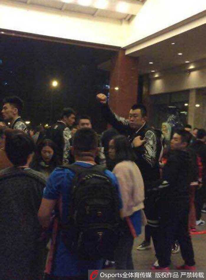 辽宁球员刘志轩在人群中被围住，他右臂挥出，拳头紧握，面部表情因激动而扭曲，旁边的人伸手阻拦却已无法挽回失控的局势。