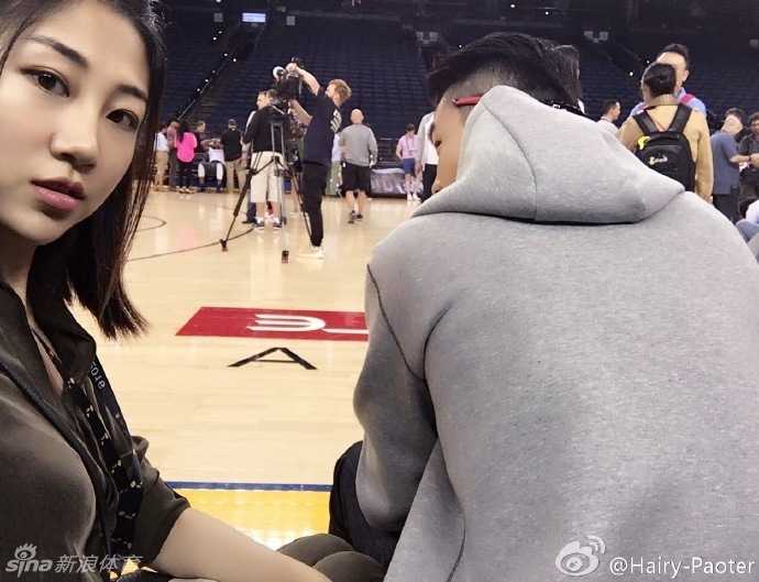 总决赛前奏:王仕鹏妻子李跑的甲骨文球场偶遇记 训练间隙,李跑来到场边的记者工作区,以球场为背景俏皮自拍。远处,一群手持长枪短炮的摄影记者正严阵以待,他们的镜头统一对准了场内正在进行投篮热身的球员,形成了一道独特的赛场风景线。