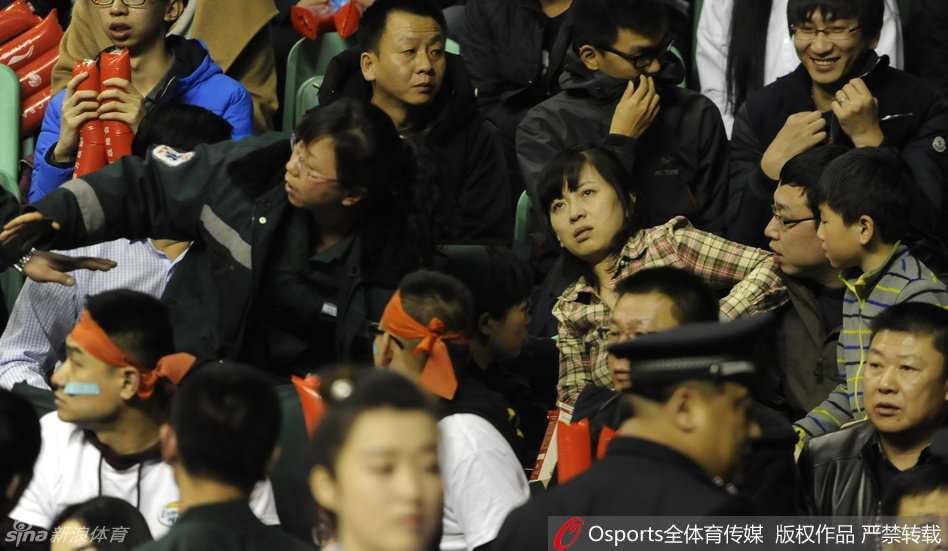 愤怒与混乱之中，辽宁队球员郭艾伦被队友和工作人员紧紧抱住，试图阻止他继续冲向人群，他脸上的表情充满了不解与愤慨。
