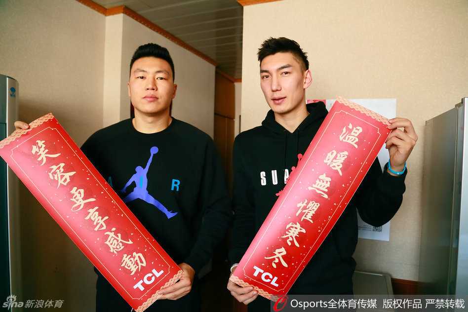 李根和可兰白克在训练馆通道内被球迷逗乐，两人不约而同地转头看向一侧，眼神中带着好奇与惊喜，似乎在回应球迷的呼唤：看哪呢看哪呢，我们在这儿！