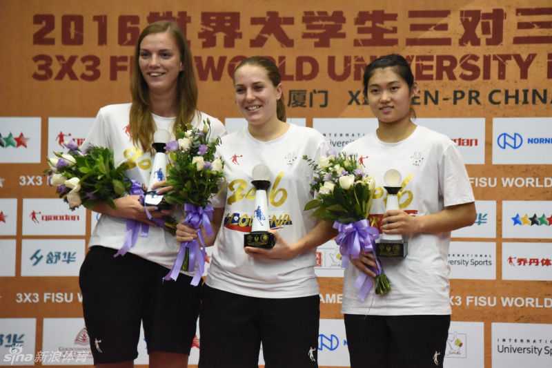 女篮赛场上，一位球员巾帼不让须眉，面对三人包夹毫无惧色，高高跃起将球放进篮筐，眼神中满是坚定与自信。