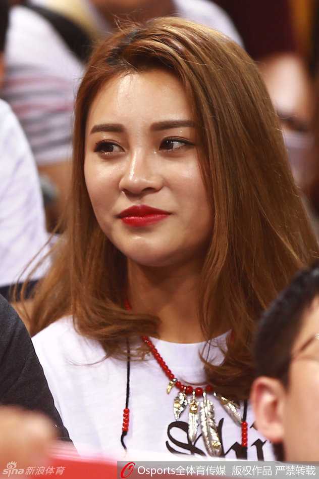 郭艾伦女友看台回眸一笑，眼神清澈，嘴角微扬，那份甜蜜仿佛能感染整个球馆。