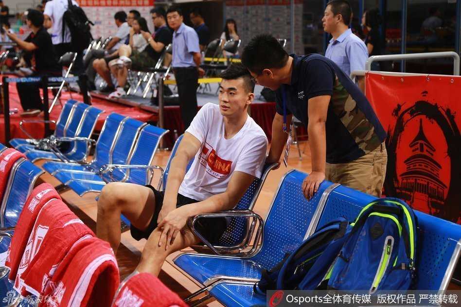 斯杯赛场边的无奈与期许 李慕豪的坎坷篮球路 坐在替补席上的李慕豪神情落寞,眼神中充满了无法上场的无奈与对赛场的渴望,身旁的队友们正在激烈热身。