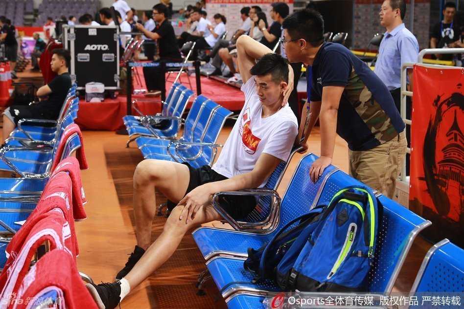 斯杯赛场边的无奈与期许 李慕豪的坎坷篮球路 镜头拉近,李慕豪低垂着头,左腿上缠着厚厚的绷带,脚踝处隐约可见冰敷的痕迹,肿胀让他甚至无法穿着鞋子。