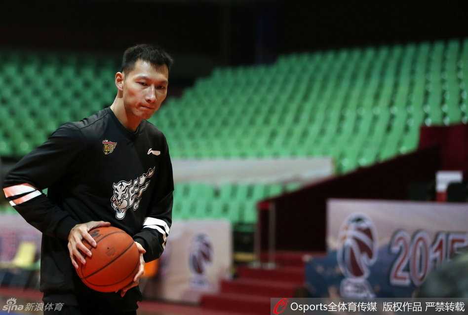 易建联拉伸时肌肉线条分明，神情专注而放松，他正利用弹力带进行肩背肌群拉伸，这套动作能有效预防高强度训练带来的损伤。