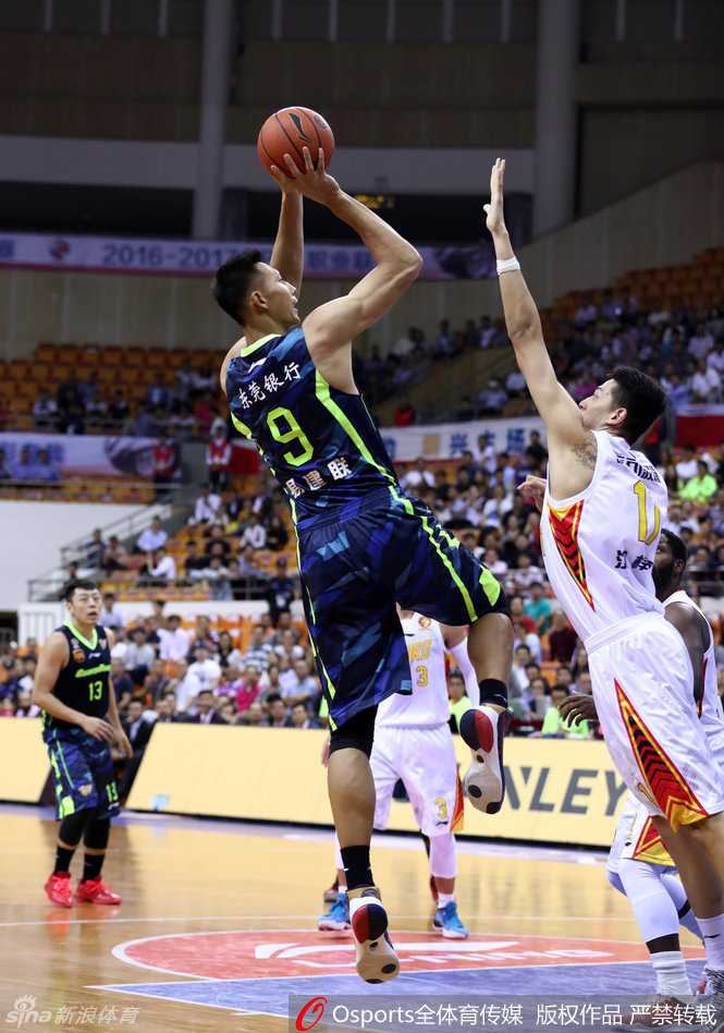 易建联王者归来:后仰跳投与霸气扣篮铸就的传奇之夜 易建联在防守球员头顶高高跃起,使出了标志性的后仰跳投,身体在空中形成一道完美的弧线,眼神专注地盯着篮筐。