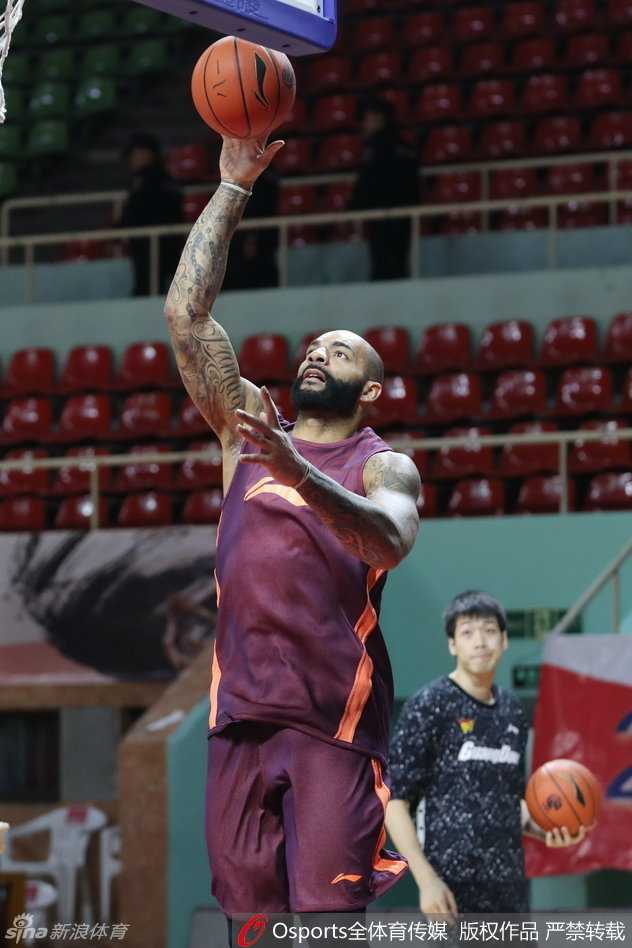 主教练杜峰神情严肃，与体能教练双手比划，细致讨论着当晚的球员轮换与体能分配策略。