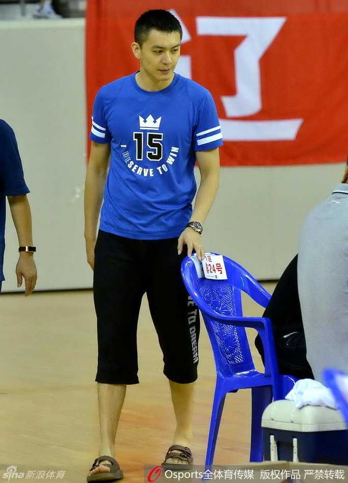 杨鸣托腮静坐于场边，眼神深邃而锐利，全神贯注地观察着场上的激烈对抗，神情若有所思。