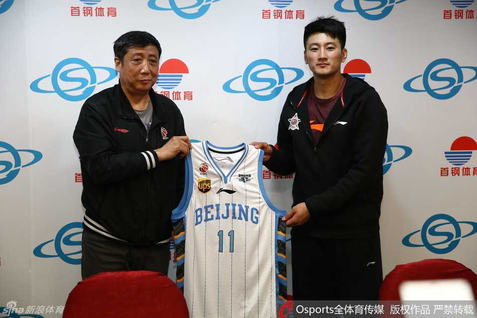 在聚光灯的照耀下，段江鹏脸上洋溢着自信的微笑，双手高高举起北京首钢队11号战袍，向全场展示这个属于他的新起点。