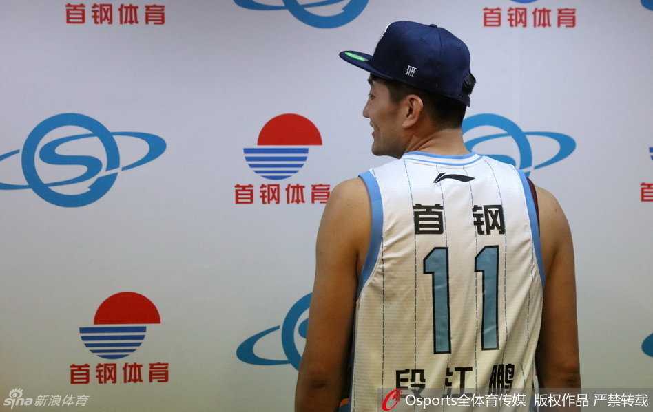 段江鹏在众多媒体镜头前侃侃而谈，身后的背景板印着北京首钢的logo，他用手势比划着对新战术的理解，显得从容不迫。