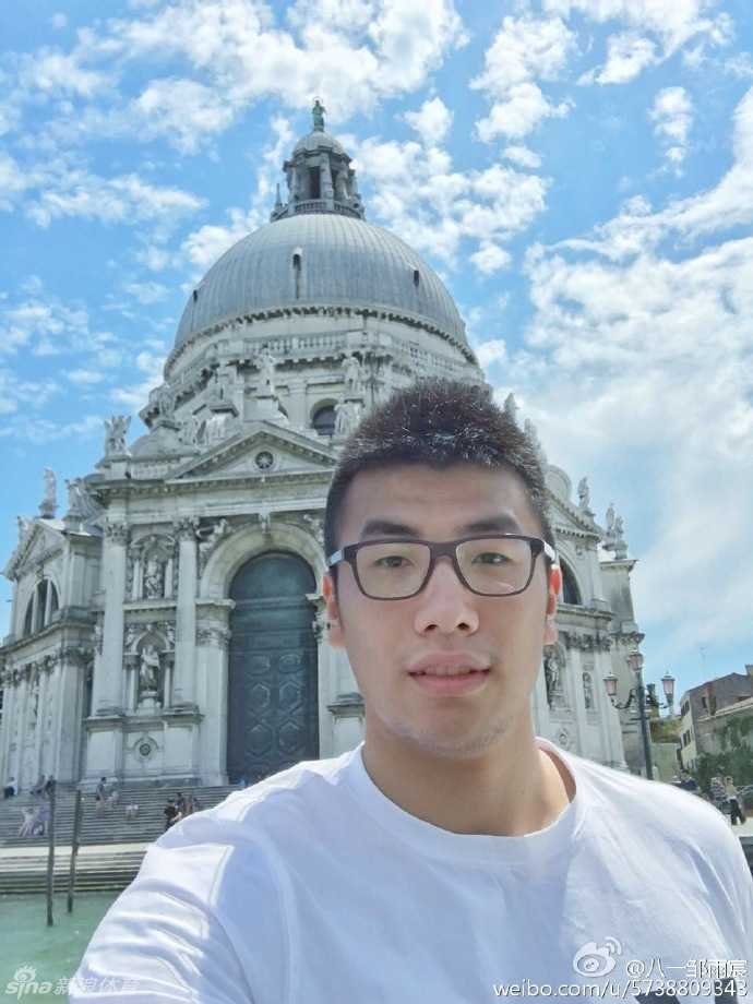 邹雨宸驻足于威尼斯街头的咖啡店旁，身后是文艺复兴风格的雕花窗棂，他眼神柔和，享受着难得的午后闲暇时光。