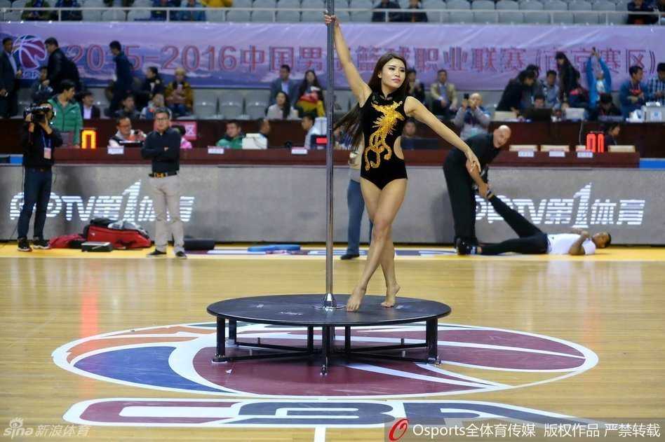 伴随着音乐高潮，舞者在钢管上一个舒展的下腰动作惊艳全场，场边的摄影记者纷纷举起长枪短炮，记录下这力与美在CBA赛场上绽放的经典瞬间。