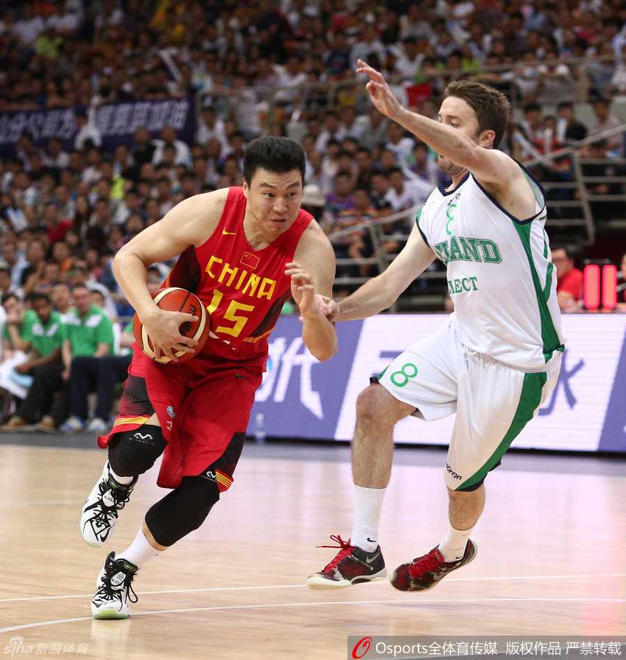 李根在亚锦赛出手三分后仍保持着投篮手型，皮球在空中划过一道优美弧线，篮筐后的球迷目光紧紧追随