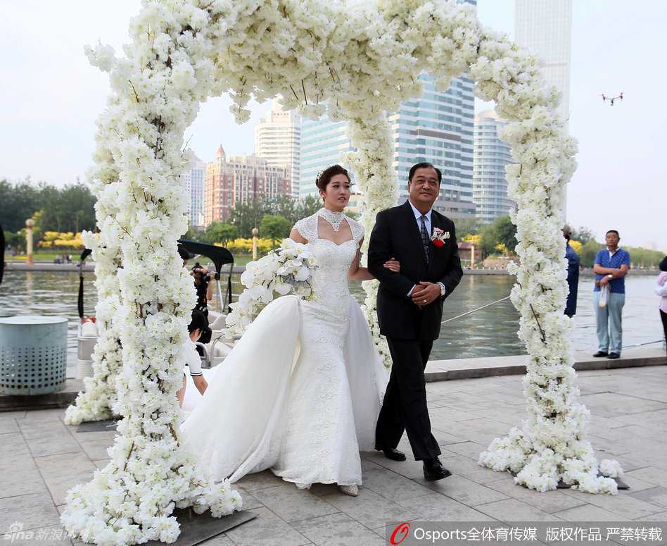 津门体坛传佳话:女排侠女李莹与男篮中锋徐磊十年爱情长跑终成眷属 父亲将女儿李莹的手郑重地交到新郎徐磊手中,这一刻的传承与托付,饱含着深沉的父爱与无限的祝福。