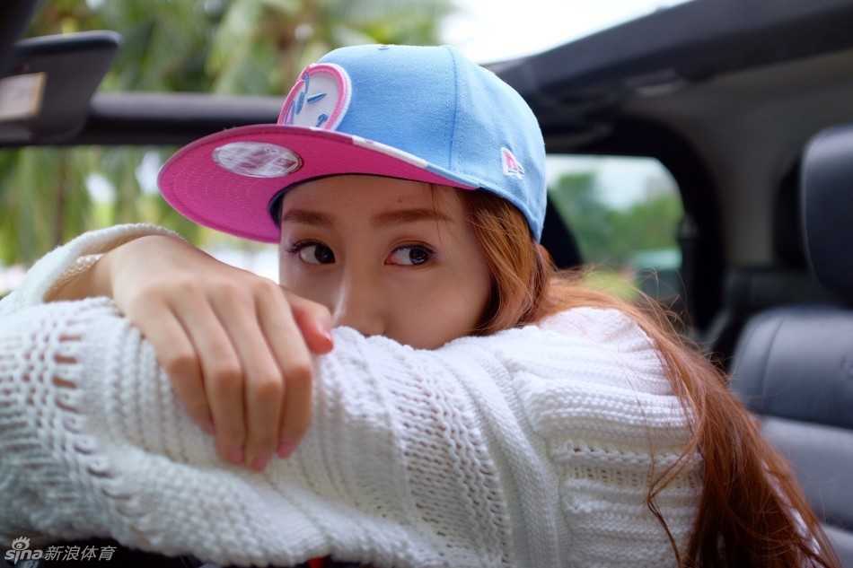 陈露置身于一片清新的热带绿植中，她穿着简约的纯色比基尼，外搭一件宽松的白色镂空罩衫，展现出模特专业的镜头表现力，笑容干净而明媚。