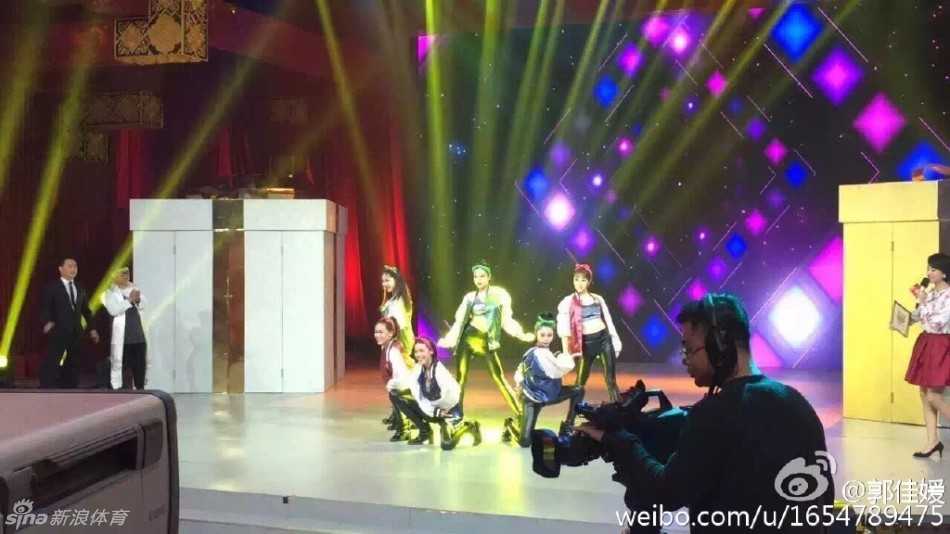 宝贝们身穿红色紧身短裙搭配红色手套，在演播厅内站成一排，灿烂笑容洋溢青春活力