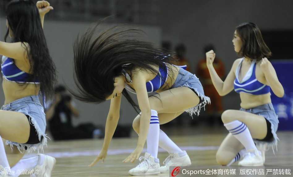 啦啦队队长高举双拳，以极具感染力的肢体语言调动全场观众的情绪，欢呼声此起彼伏
