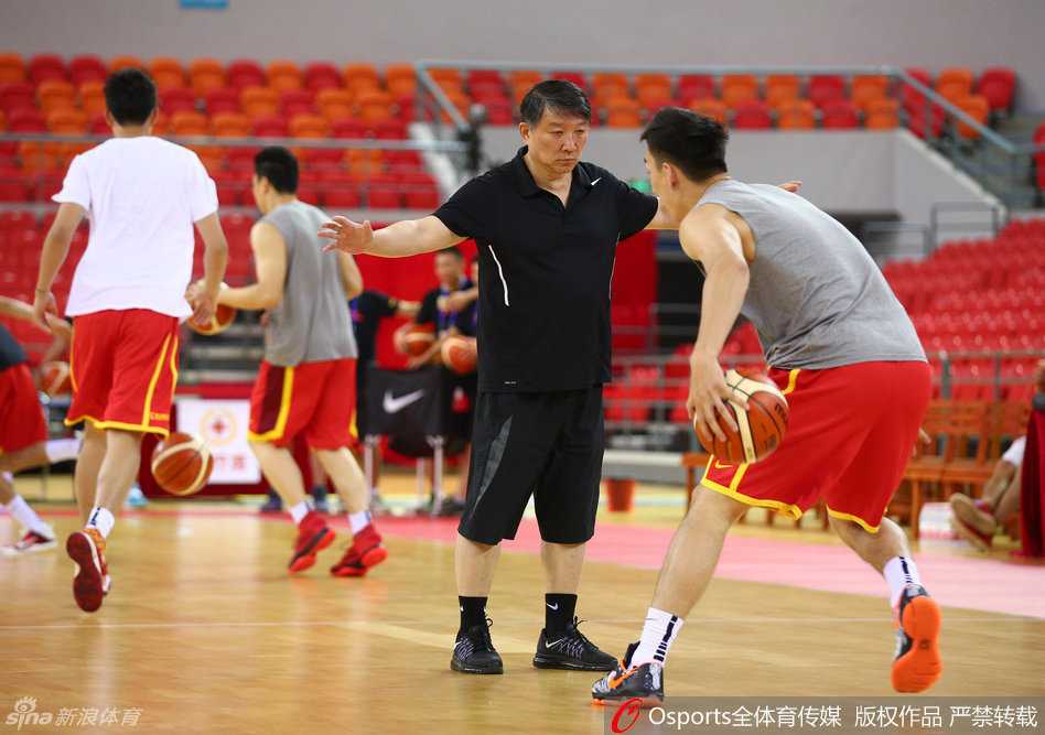 睢冉在训练间隙与李楠指导并肩而立，两人神情专注地讨论着场上的战术跑位。作为队中的防守悍将，睢冉认真聆听着指导的每一个细节，身后的队友们正挥汗如雨，这幅画面定格了教练组与核心球员之间无间的信任与团结。