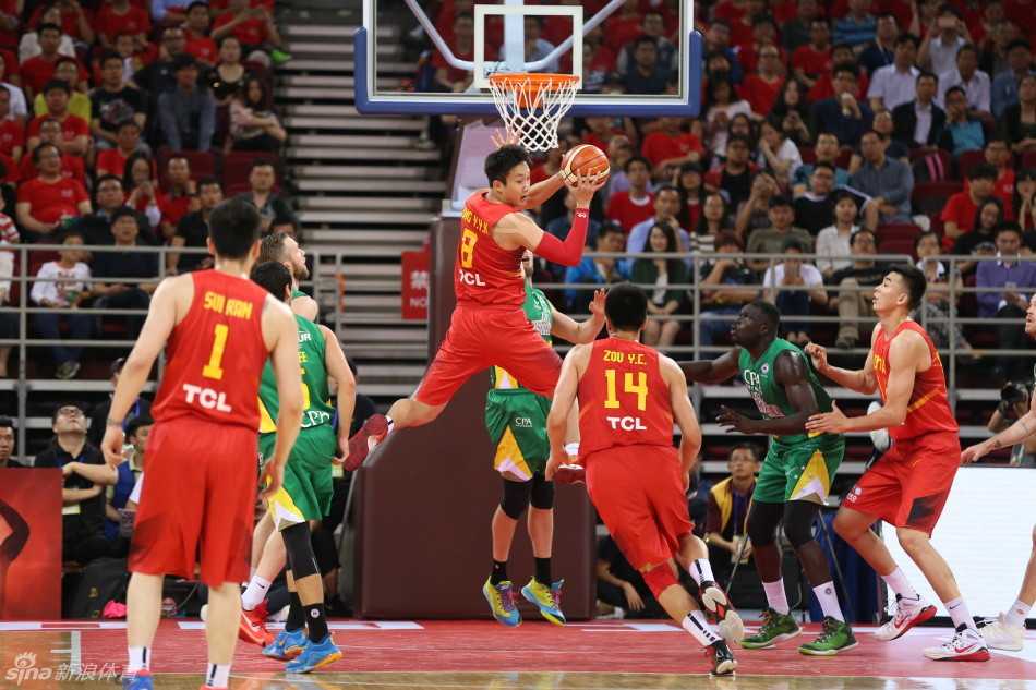 热血铸就长城,定格中国男篮的拼搏瞬间 满头白发的宫鲁鸣指导神情专注地与刚刚下场的周鹏交流战术,周鹏一边擦汗一边认真聆听并用手势表达自己的场上观察,身后是其他替补席球员。