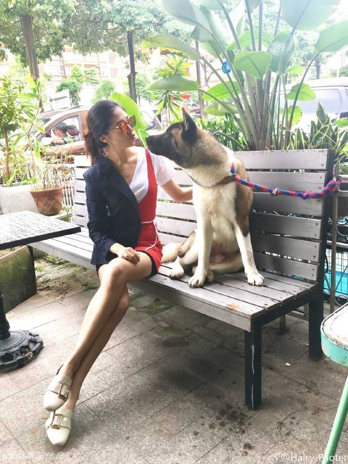 闲暇时光，李跑坐在户外休闲椅上对镜浅笑，黑色连衣裙衬托出她白皙的皮肤，整体造型简约大方又不失时尚感。