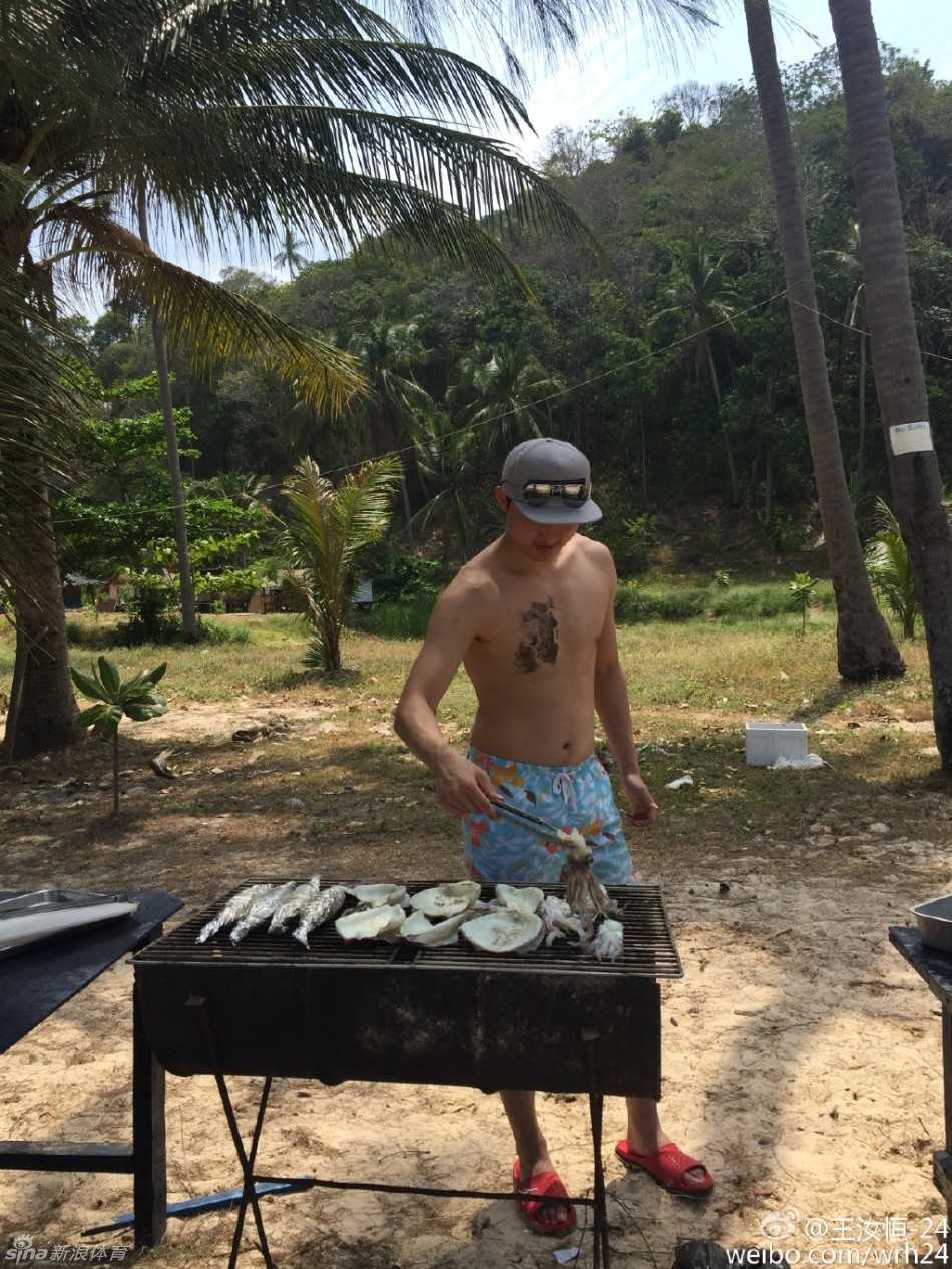 王汝恒专注地翻转着烤架上的大虾和扇贝，炭火升腾起烟雾，海鲜烧烤大餐正在进行