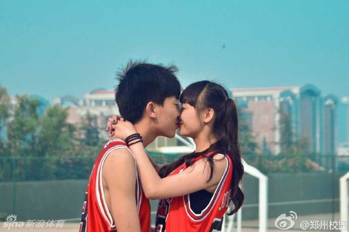 夕阳的暖光给整个篮球场镀上了一层金色，穿着同款球衣的男孩和女孩面对面站立，彼此深情凝望，眼神中充满了对未来的憧憬和对彼此的爱意。