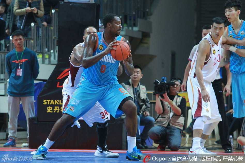 疆浙大战风云录:西热力江的血性与布拉切的巨人身姿 新疆队外援布拉切在浙江队内线群中强行转身,利用厚实的身板扛开防守,眼神坚毅地盯着篮筐,准备完成一次势在必得的强攻。